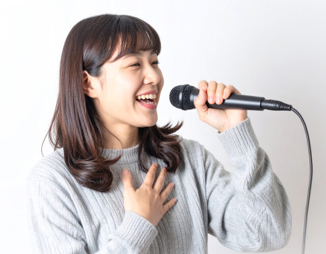 笑顔で発声練習をする女性